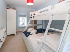 A bunk bed room with a white wardrobe, a window, and a radiator.