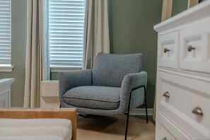 A room with a grey armchair, a white dresser, and a window with blinds. - Go!#37 - WINDSOR ISLAND (Davenport)