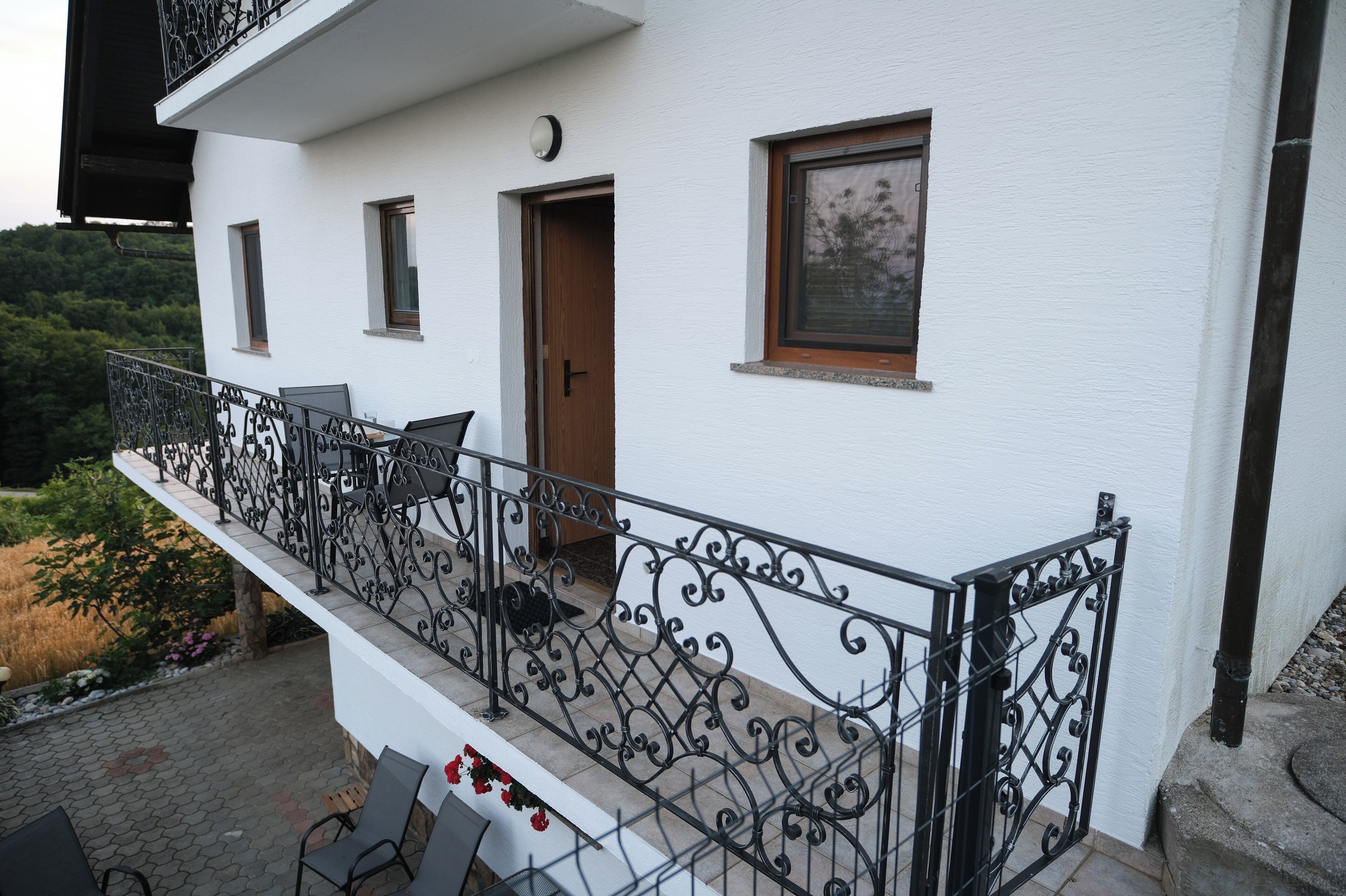 Ein weißes Gebäude mit Balkon, Tür und Fenster.
