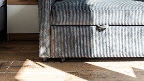 Een moderne woonkamer met een bank, een houten bijzettafeltje en een stopcontact.