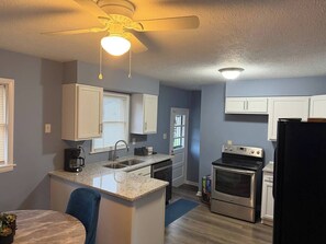 A kitchen with a central island, a stove, and a refrigerator.
