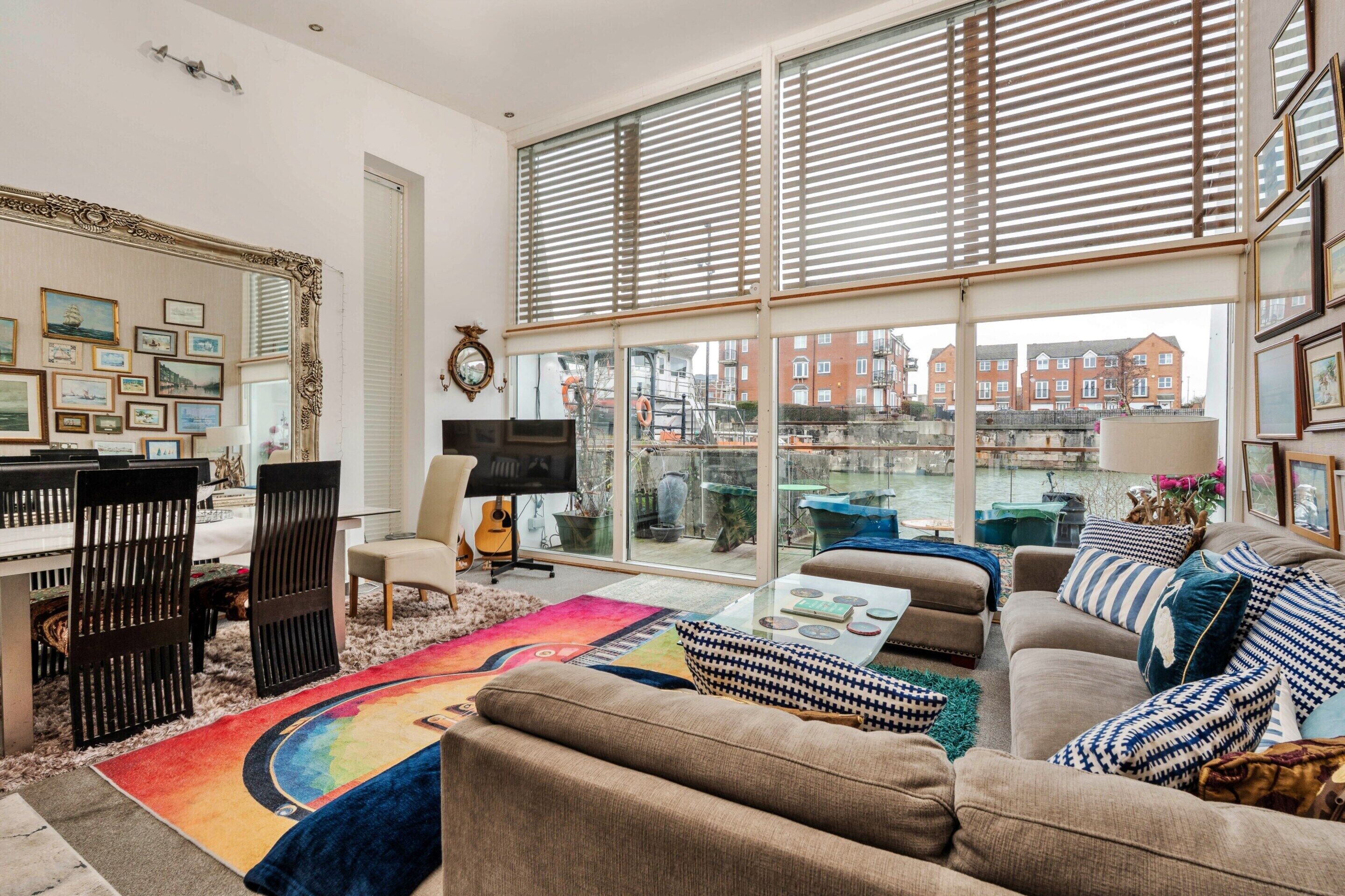 A spacious living room with a large window, a television, and a variety of seating options.