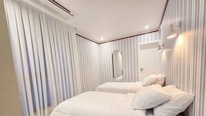 Un dormitorio con cama, cortinas, un espejo y luces en la pared.