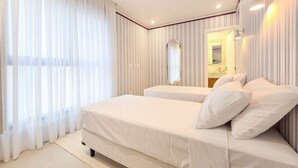 Una habitación de hotel con una cama grande, un espejo y una ventana con cortinas.