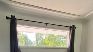 A room with two leather armchairs, a small table with a tissue box, and a window with curtains.