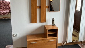 A room with a wooden wardrobe, a mirror, and a small table with a speaker. - Roman Villa, Sleeps 8 With Parking and Garden (Roman)