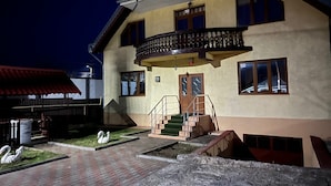 A two-story building with a balcony, a staircase, and a small garden with swan sculptures. - Roman Villa, Sleeps 8 With Parking and Garden (Roman)
