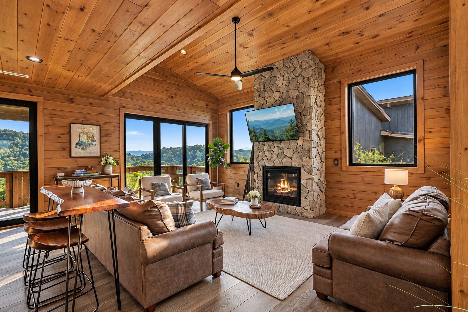 A spacious living room with a stone fireplace, leather sofas, and a large TV.