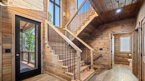 Un intérieur en bois avec un escalier, une porte et une fenêtre.