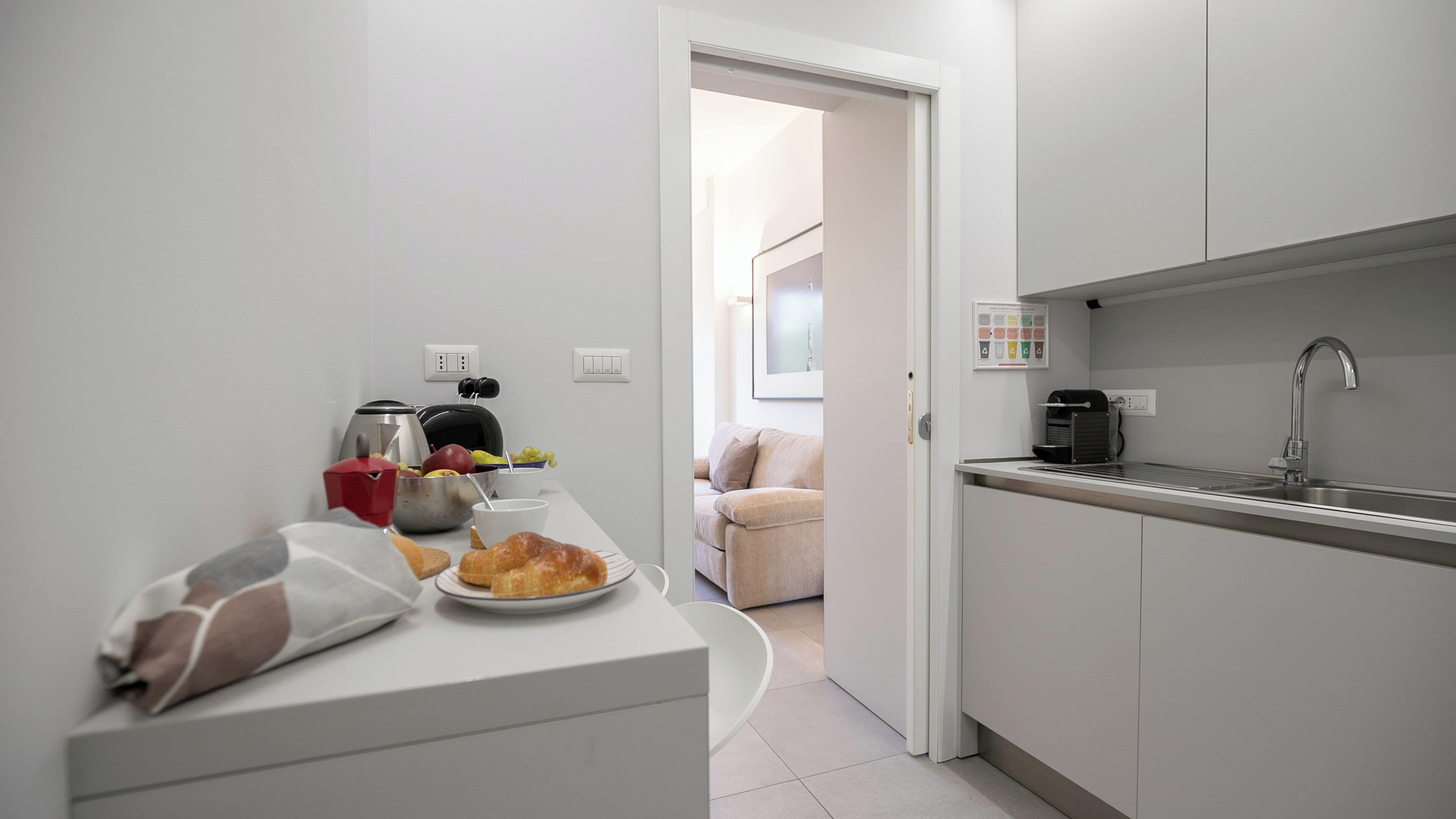 Une cuisine moderne dotée d’un évier encastré, d’une machine à café et d’un coin repas avec une table mise pour le repas.
