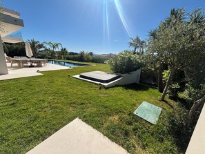 A backyard with a swimming pool, a patio with outdoor furniture, and a well-maintained lawn. - Exceptional new contemporary villa with air conditioning, ocean views, a private pool, and a hot tub (Saint-Cyr-sur-Mer)