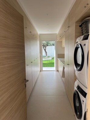 A modern laundry room with built-in washing machines, a clear view to the outdoors, and a minimalist design. - Exceptional new contemporary villa with air conditioning, ocean views, a private pool, and a hot tub (Saint-Cyr-sur-Mer)