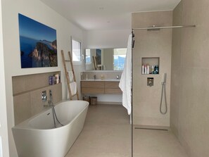 A modern bathroom with a freestanding bathtub, a glass-enclosed shower, and a large mirror. - Exceptional new contemporary villa with air conditioning, ocean views, a private pool, and a hot tub (Saint-Cyr-sur-Mer)