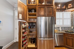 A kitchen with wooden cabinets, a stainless steel refrigerator, and a built-in oven. - 4 Blocks to IU! 3BR Stay w/ Parking, Gym & FirePit (Bloomington)