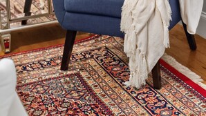 A blue armchair with a white throw blanket, a glass side table with a tissue box, and a patterned rug. - Black Walnut - 4 Blocks to Kirkwood / Downtown w/ at home Gym (Bloomington)