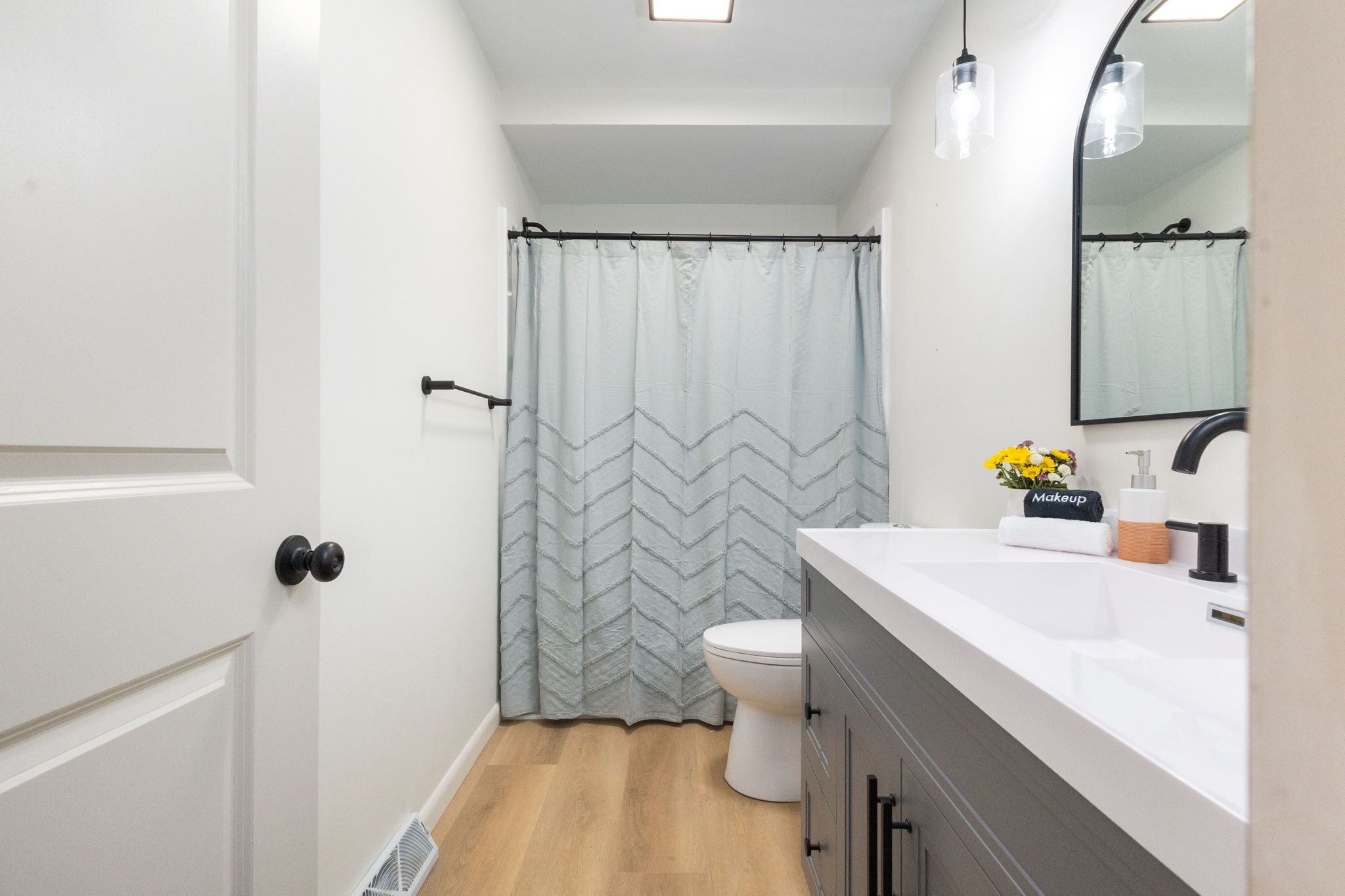 Un baño con cortina de ducha, inodoro, lavabo y espejo.
