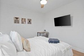 A bedroom with a bed, a desk, and a TV mounted on the wall. - Biltmore 2BR Bungalow - Desk, Parking, Patio (Phoenix)