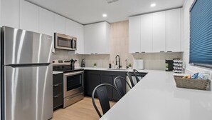 A modern kitchen with stainless steel appliances, a microwave, and a built-in oven. - Biltmore 2BR Bungalow - Desk, Parking, Patio (Phoenix)