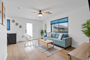 Ein modernes Wohnzimmer mit einer Couch, einem Couchtisch und einem Deckenventilator.