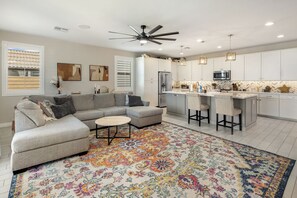 A modern living room with a sofa, coffee table, and patterned rug. - Bright & Modern Home w/ Open Living, Great Area, & Perfect for Families! (Sun City West)