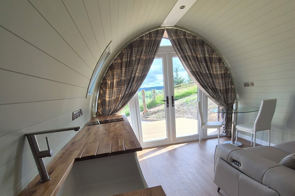 Ein modernes Interieur mit einem Holztisch, einer Couch und Blick durch eine Glastür.