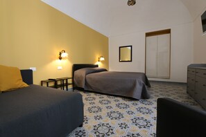 Une chambre avec deux lits, une commode, un miroir et un revêtement de sol à motifs.
