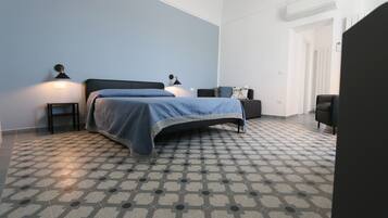 A bedroom with a bed, bedside tables, a chair, and a patterned floor.