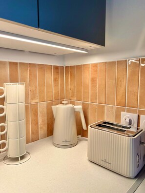 A kitchen with a modern design, featuring a coffee maker, a kettle, and a toaster on the countertop. - June House in the Heart of the Luberon—Ducted Air Conditioning, All the Comforts, and a Private Garden (Saignon)