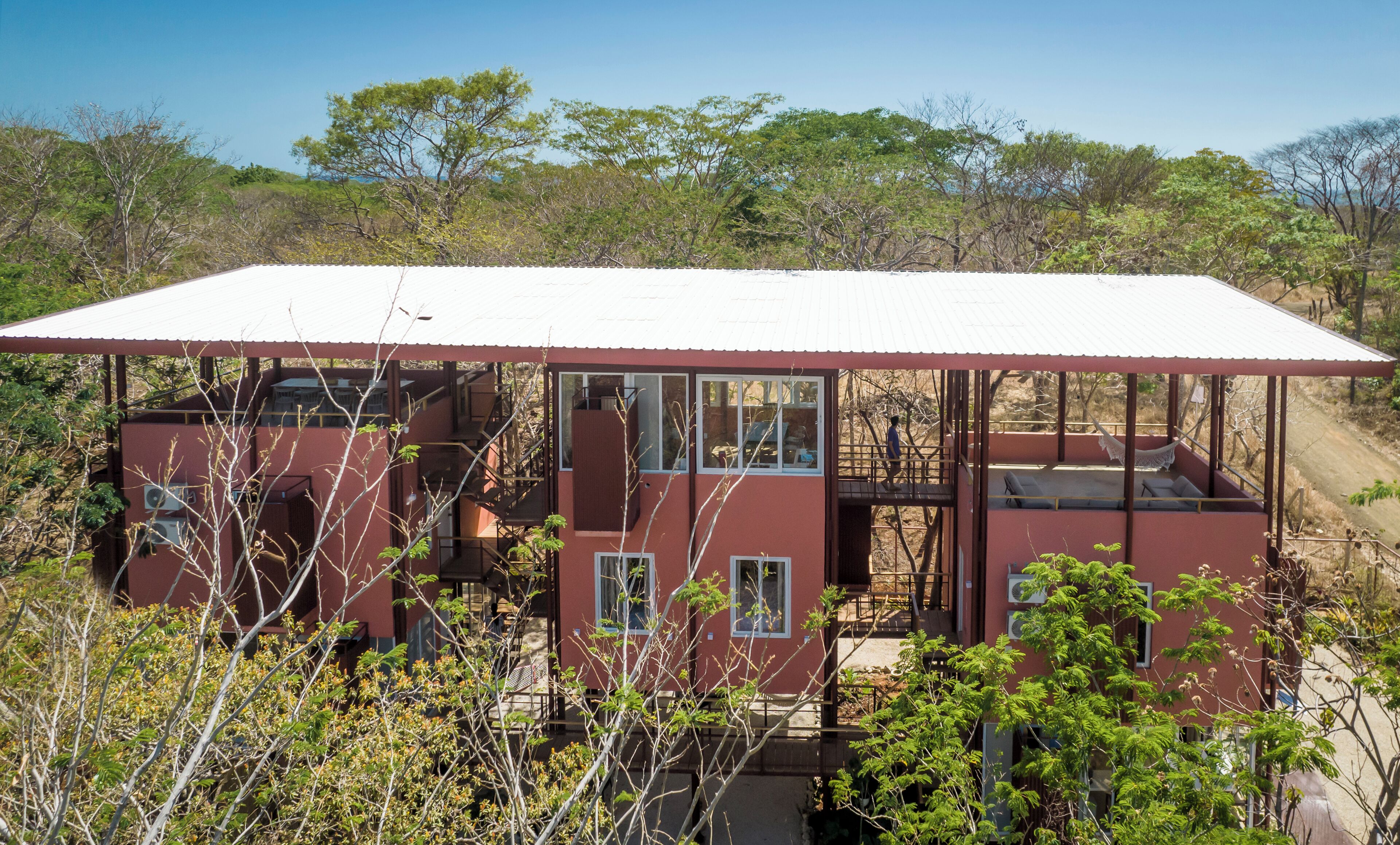 Un edificio rojo con varias ventanas y un espacio al aire libre cubierto.