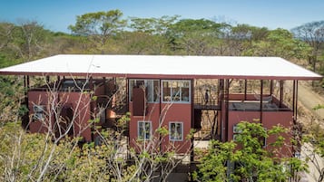 A red building with multiple windows and a covered outdoor area.