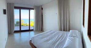 A bedroom with a large bed, a view of the sea through a sliding door, and a balcony. - ALIZES SERRA GRANDE - AN INCREDIBLE BAHIAN EXPERIENCE AND THE BEST VIEW OF THE COAST (Uruçuca)