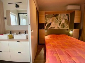 Ein Schlafzimmer mit einem Bett, einem Nachttisch und einem Spiegel.