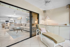 Ein modernes Wohnzimmer mit Glastrennwand, einer Couch, einem Couchtisch und einem Sessel.