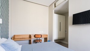A hotel room with a bed, a desk, a chair, a wardrobe, and a television. - Weaver Suite 5 By Dimorra  (Naples)