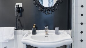 A bathroom with a white sink, a black telephone, and a mirror with an ornate frame. - Weaver Suite 5 By Dimorra  (Naples)