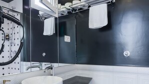 A modern bathroom with a white sink, black countertop, and a large mirror. - Weaver Suite 5 By Dimorra  (Naples)