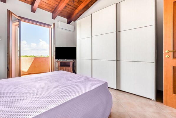 A bedroom with a bed, a wardrobe, and a television.
