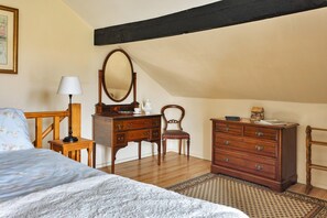 A bedroom with a bed, a dresser, a chair, a desk, and a mirror. - Grand Devon Country House for 15 (Leyburn)