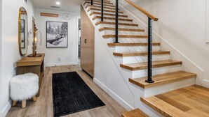 Eine moderne Treppe mit Holzdielen und Metallgeländern, die zu einer zweiten Etage führt.