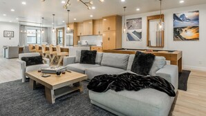 Ein modernes Wohnzimmer mit einem grauen Ecksofa, einem Holztisch und einem Kamin.