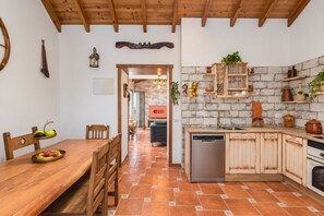 Una cocina con armarios de madera, lavavajillas y un salpicadero de pared de ladrillo.