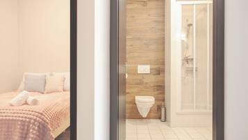A hotel room with a bed, a shower, and a toilet.