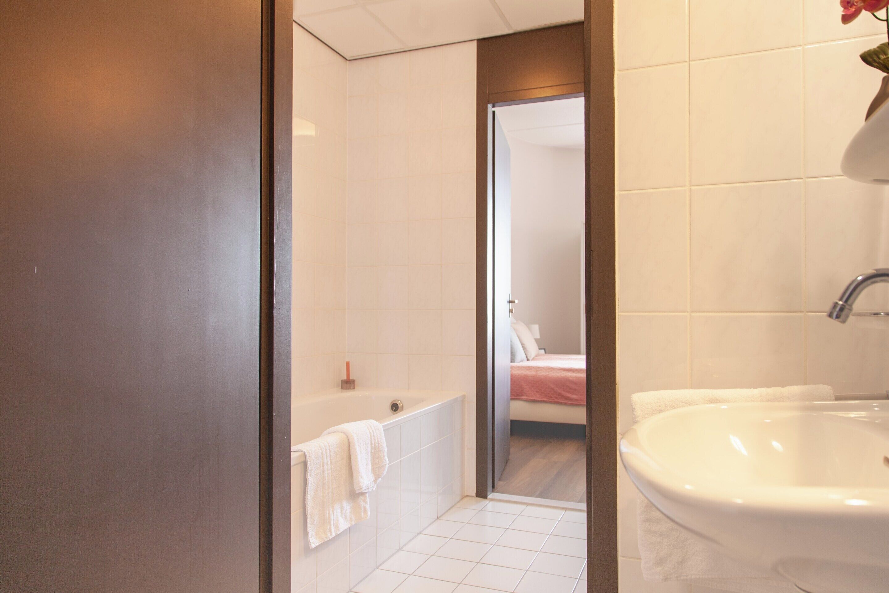 Un bagno moderno con una vasca, un lavandino grande e una cabina doccia.