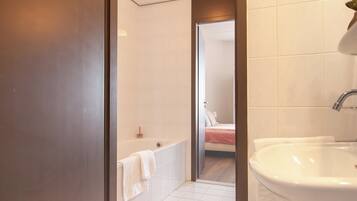 Un bagno moderno con una vasca, un lavandino grande e una cabina doccia.