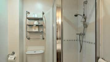 A bathroom with a toilet, a glass shower enclosure, and a towel rack.