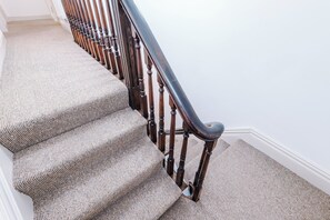 A carpeted staircase with wooden balusters and a handrail. - The St Annes Beach Collection (Lytham St Annes)