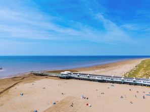 Une plage avec une jetée et un train.