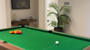 A pool table with balls, a potted plant, and a painting on the wall. - Emerald Tide Hotel (Blackpool)