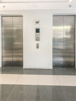 A modern elevator with a control panel labeled 'GF' in a clean, minimalistic lobby area.