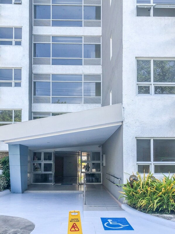 A modern building with a flat facade, large windows, and a covered entrance area. - Seawind Condominium - Davao City (Davao City)